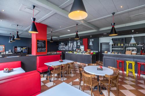 a restaurant with tables and chairs and a bar at Ibis Częstochowa in Częstochowa
