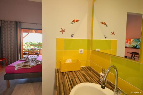 1 dormitorio con 1 cama y baño con lavabo. en Poz Lagon en La Saline les Bains