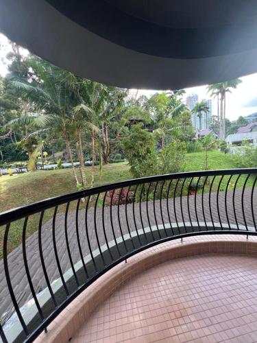 a balcony with a view of a park with palm trees at Lovely apartment in Genting Highlands. in Genting Highlands