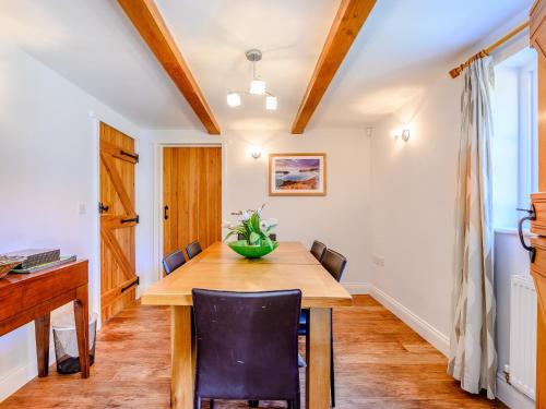a dining room with a wooden table and chairs at Hambury House in West Lulworth