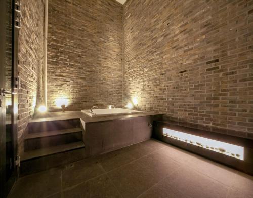 a bathroom with a sink and a brick wall at JS Boutique Hotel in Hwaseong