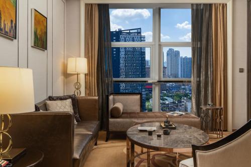 a living room with a couch and a large window at 长沙珠江花园酒店 in Changsha