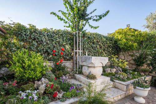 a garden with a stone fountain and flowers at Villa Amigo in Podstrana