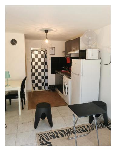 une cuisine avec un réfrigérateur blanc et une table dans l'établissement Mer et montagne, à Perpignan