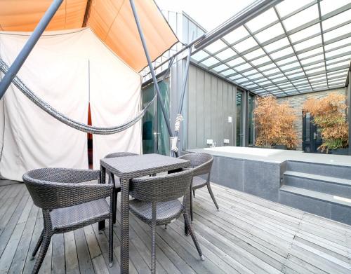a patio with a table and chairs and a tub at JS Boutique Hotel in Hwaseong