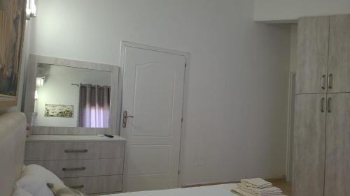 a white bathroom with a sink and a mirror at Italian style Apartment in Durrës