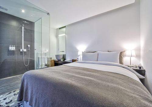 a bedroom with a large bed and a glass shower at JS Boutique Hotel in Hwaseong