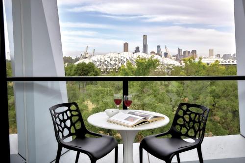 a table with two chairs and wine glasses on a balcony at 381 Cremorne in Melbourne