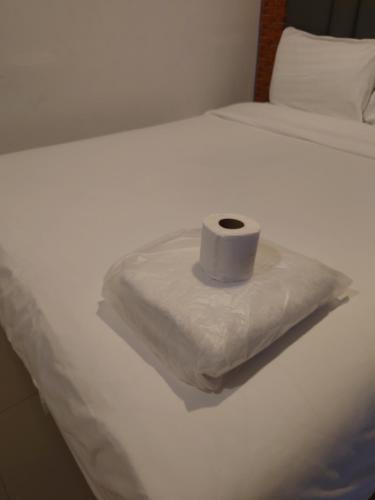 a roll of toilet paper sitting on top of a bed at Baan der Bruyn SHA in Jomtien Beach