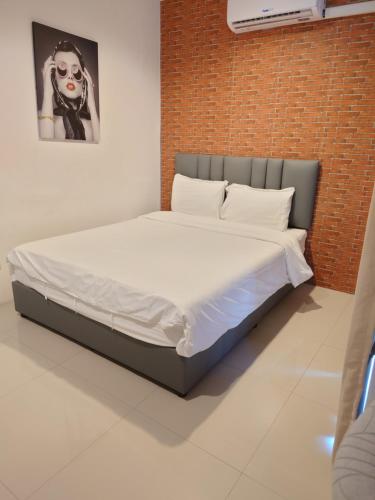 a bed in a room with a brick wall at Baan der Bruyn SHA in Jomtien Beach
