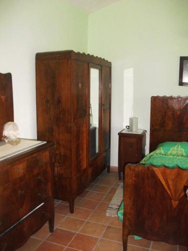 a bedroom with wooden furniture and a bed and a dresser at Casino Tonti Iarussi in Forlì del Sannio