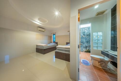 La salle de bains est pourvue de 2 lits, de toilettes et d'un lavabo. dans l'établissement U Resort Nakhon Ratchasima, à Nakhon Ratchasima