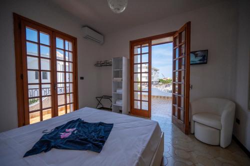 una camera da letto con un letto, una sedia e finestre di Retreat dell'Orso - Villa per Vacanze in centro - Frontemare a Torre dell'Orso