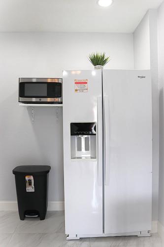 a white refrigerator with a microwave on top of it at River Lane Studio in Riverview
