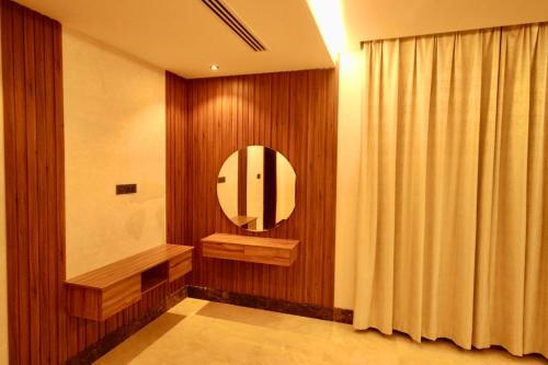 a bathroom with a round mirror and a curtain at لاكجري صلالة Luxury salalah Villa in Salalah