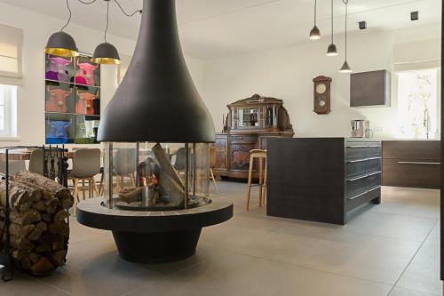 a kitchen with a fire place in the middle of a room at Viitina vesiveski in Rõuge