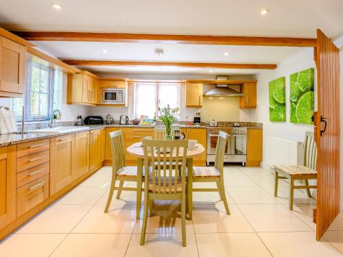 a kitchen with wooden cabinets and a table and chairs at Hambury House in West Lulworth