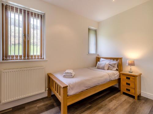 a small bedroom with a bed and a window at Derwen Haidd in Llanafan