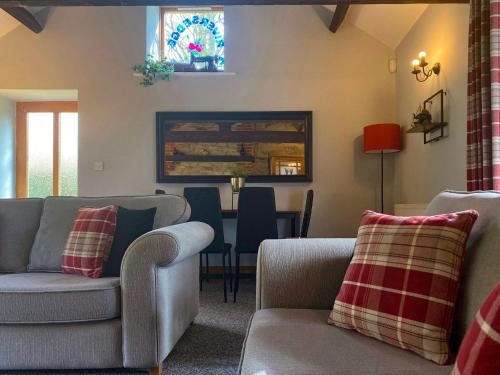 a living room with two couches and a table at Rivers Edge Cottage in Shotley Bridge