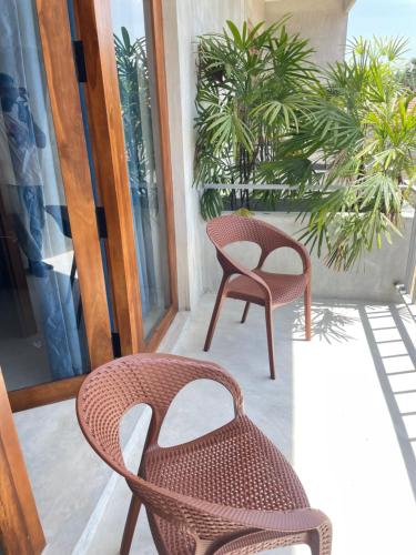 a pair of chairs sitting on a porch at Doppel Gangs Arugambay in Arugam Bay
