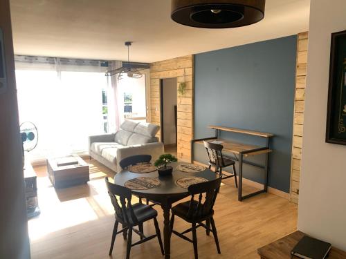 a living room with a table and chairs and a couch at Chez Titi in Saint Lo