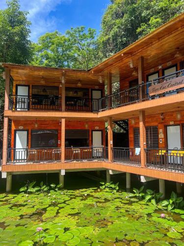a large wooden building with decks and a pond at Tam Coc Central Bungalow-Hostel in Vũ Lâm