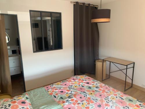 a bedroom with a bed and a mirror and a table at Chez Titi in Saint Lo