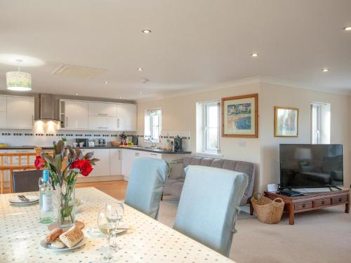 a kitchen and living room with a table and chairs at The White House in Poundstock
