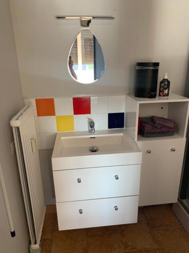 a bathroom with a sink and a mirror at Chez Titi in Saint Lo