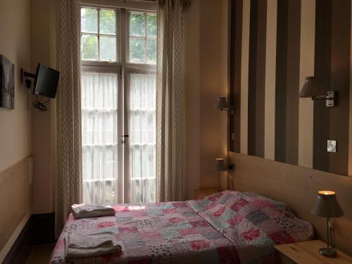 a bedroom with a bed and a large window at St George Hotel in London