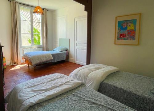 a room with two beds and a window at Maison de Famille avec Jardin - Coeur du village - Zoo de Beauval in Saint-Aignan