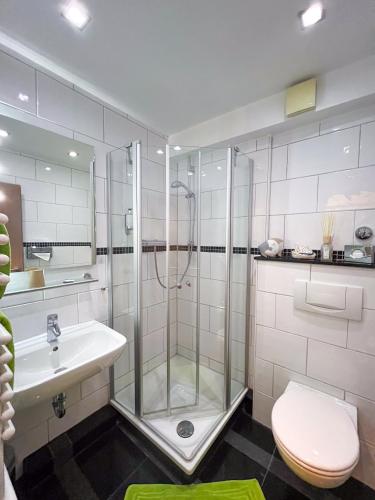 a bathroom with a shower and a toilet and a sink at Hotel Am Sportpark in Duisburg
