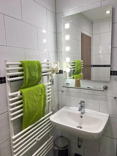 a white bathroom with a sink and a mirror at Hotel Am Sportpark in Duisburg