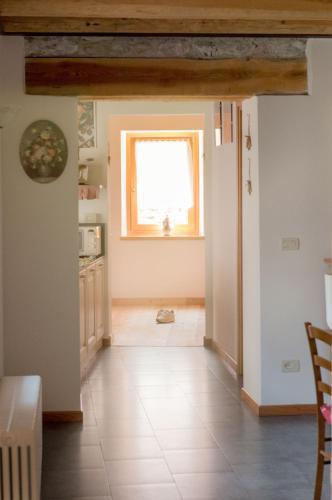 a kitchen with a window and a tile floor at Albergo Diffuso Dolomiti in Forni di Sotto