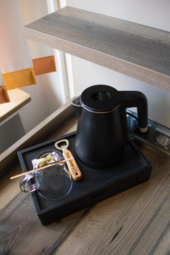 a black tea kettle on a tray on a table at Hotel Am Sportpark in Duisburg