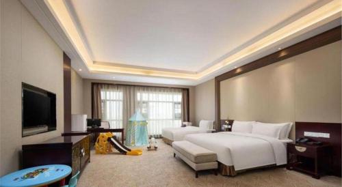 a large hotel room with a bed and a tv at Linyi Blue Horizon International Hotel Yi He in Linyi