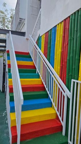 a colorful staircase with a rainbow wall at KK Sunset Villa- Full Sunset Balcony, Mosquito Free, 4K TVs, 5G WIFI and more! in Kota Kinabalu
