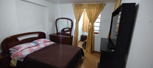a bedroom with a bed and a tv and a window at Hospedaje Solianka in Bogotá