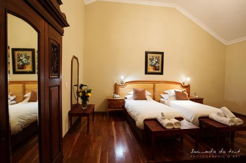 a bedroom with two beds and a mirror at Kleinkaap Boutique Hotel in Centurion