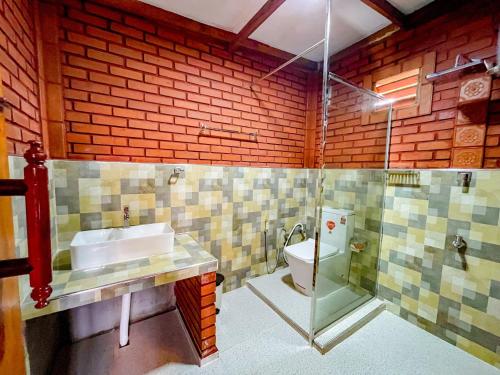 a bathroom with a sink and a toilet at Sigiriya Elegant Resort in Sigiriya