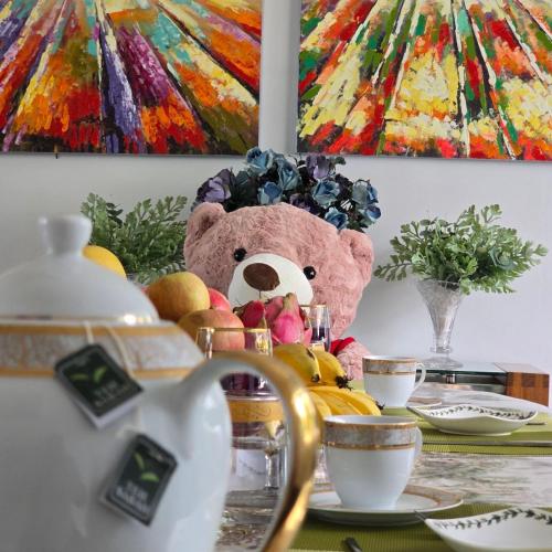 a stuffed teddy bear sitting on a table with food at KK Sunset Villa- Full Sunset Balcony, Mosquito Free, 4K TVs, 5G WIFI and more! in Kota Kinabalu