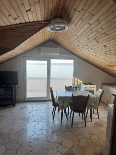 a dining room with a table and chairs and the ocean at Apartments Villa Suzana Including Private Pool in Selca