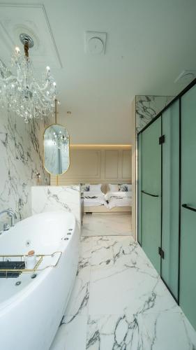 a bathroom with a white marble floor and a tub at Eudaimonia Poolvilla Jeju 에다모니아 함덕풀빌라 in Jeju