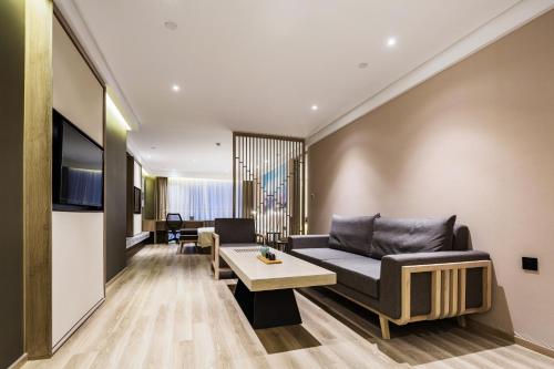 a living room with a couch and a table at Atour Hotel Qingdao May Fourth Square Yunxiao Road in Qingdao