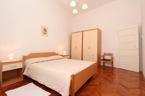 1 dormitorio con 1 cama, armario y silla en Apartment Riki, en Rovinj