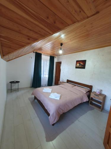 a bedroom with a large bed and a wooden ceiling at Cabana belvedere (VIS) in Colibiţa