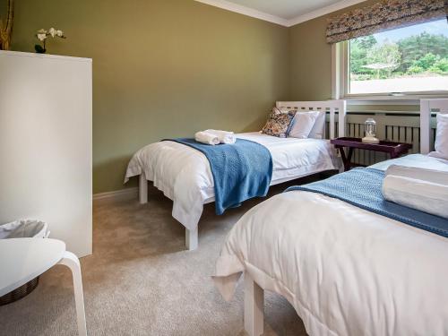 a bedroom with two beds and a window at Rowan Lodge in Resolis