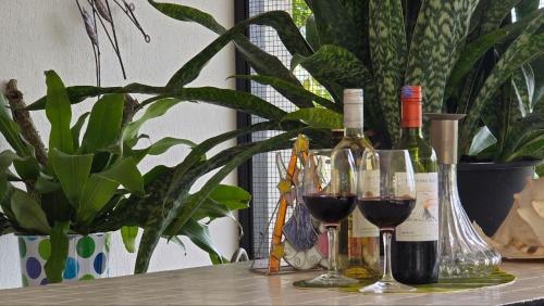 a table with wine bottles and glasses of wine at KK Sunset Villa- Full Sunset Balcony, Mosquito Free, 4K TVs, 5G WIFI and more! in Kota Kinabalu