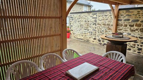 une table et des chaises sur une terrasse avec une table dans l'établissement Les Forsythias, à Messeix