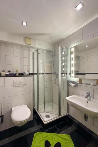 a bathroom with a shower and a toilet and a sink at Hotel Am Sportpark in Duisburg